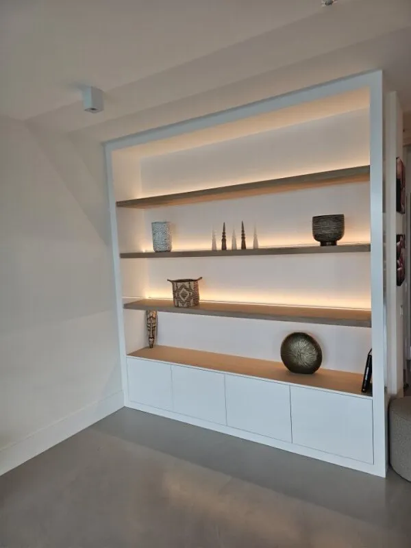 Witte maatwerk kastwand met eiken planken en geïntegreerde ledverlichting in Amsterdam